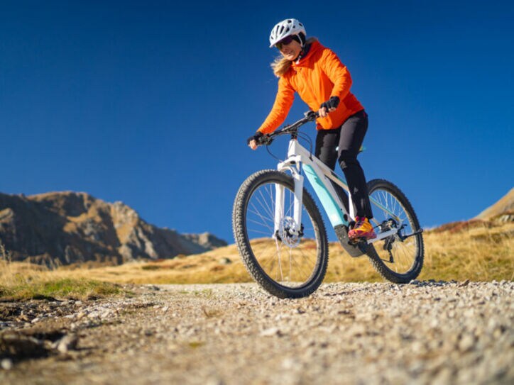 Eine Frau fährt auf einem Mountainbike einen Berg herunter