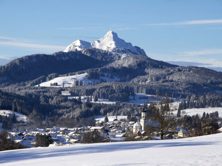 Ein idyllischer, schneebedeckter Ort am Fuße eines Berges mit Skipisten