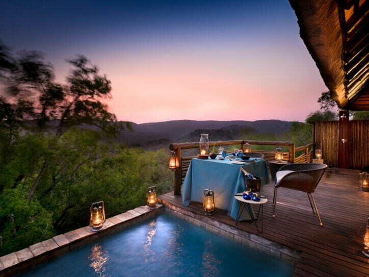 Privater Dinner-Bereich auf offener Terrasse mit Blick in die afrikanische Landschaft.