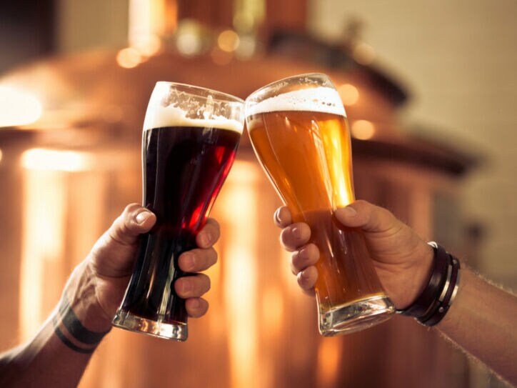 Mit zwei gefüllten Biergläsern wird angestoßen