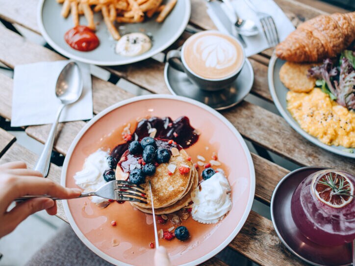 Drei üppig mit Essen befüllte Teller, darunter Pfannkuchen.