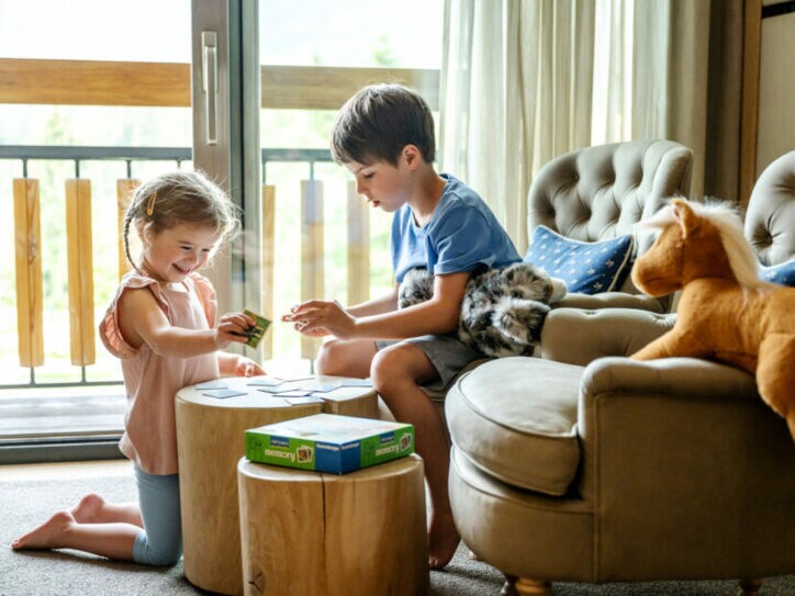 Zwei Kinder spielen in einem Hotelzimmer Memory
