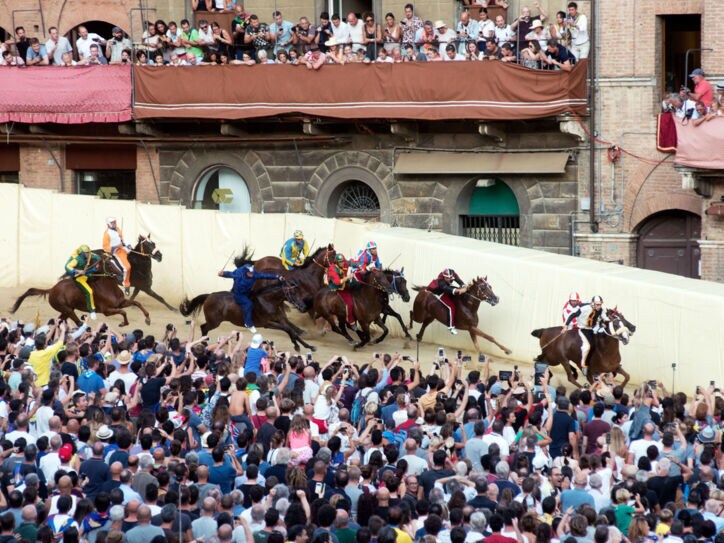 Reiter und Publikum beim Pferderennen Palio di Siena auf dem mittelalterlichen Platz der Stadt