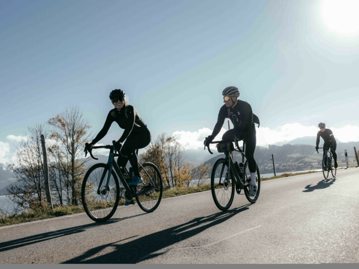 Mehrere Radfahrende auf einer Straße bei Sonnenschein