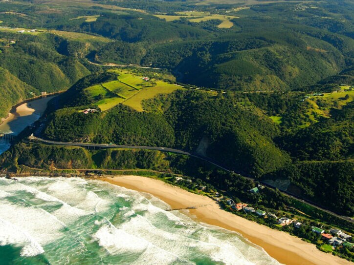 Luftaufnahme der Garden Route, die durch grüne Wälder entlang der Küste führt