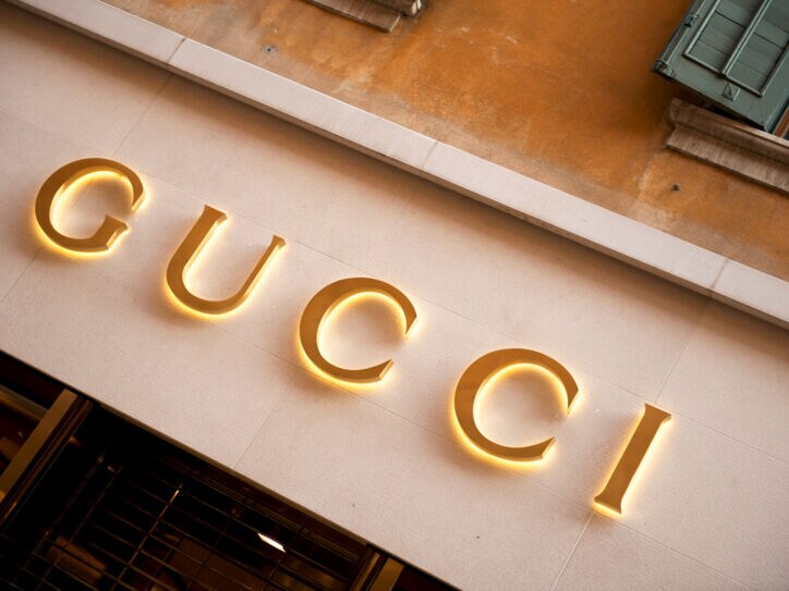 Das Logo von Gucci in Goldlettern an einer mediterranen Hausfassade