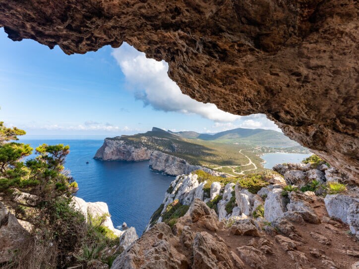 Blick zwischen Felsen hindurch auf eine Landzunge Sardiniens