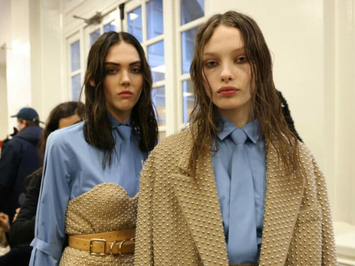 Zwei weibliche Models in eleganter Kleidung in der Farbkombination Beige und Hellblau im Backstage-Bereich einer Modenschau