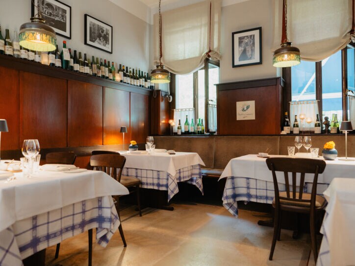 Gemütlicher Speiseraum mit Holzverkleidung und eingedeckten Tischen in einer Brasserie.