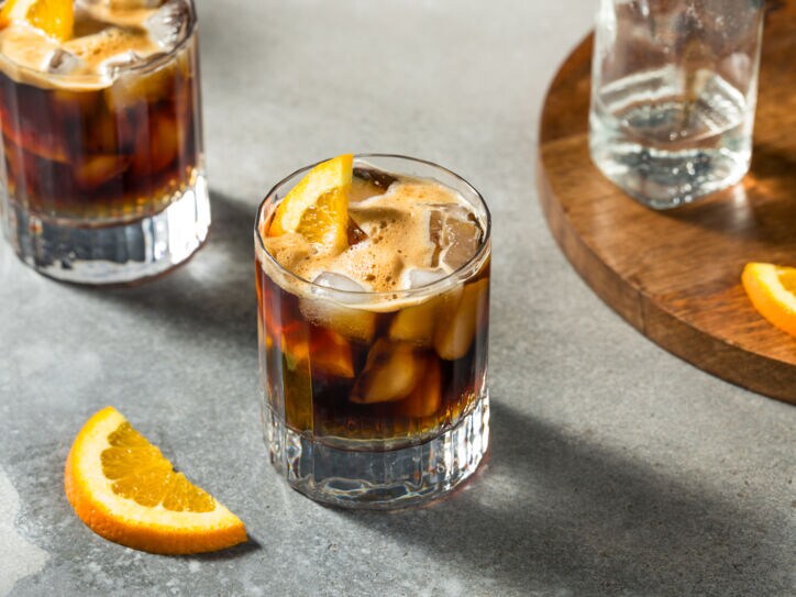 Zwei Gläser Espresso Tonic mit Eiswürfeln und Orangenscheiben.