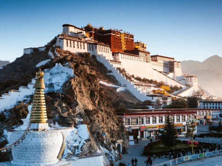 Buddhistische Tempelanlage auf einem Berg vor Gipfelpanorama.