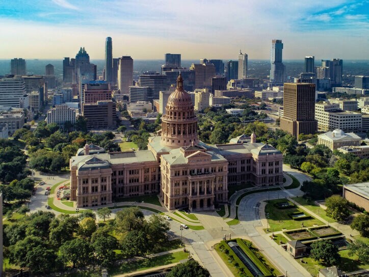 Texas State Kapitolgeböude vor der Skyline von Austin aus der Luftperspektive.
