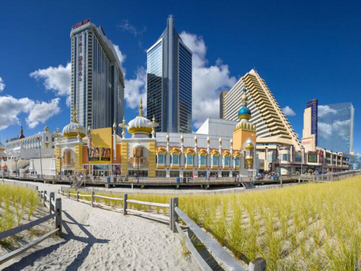 Strandpromenade mit Gebäude im orientalischen Stil vor Hochhäusern unter blauem Himmel.