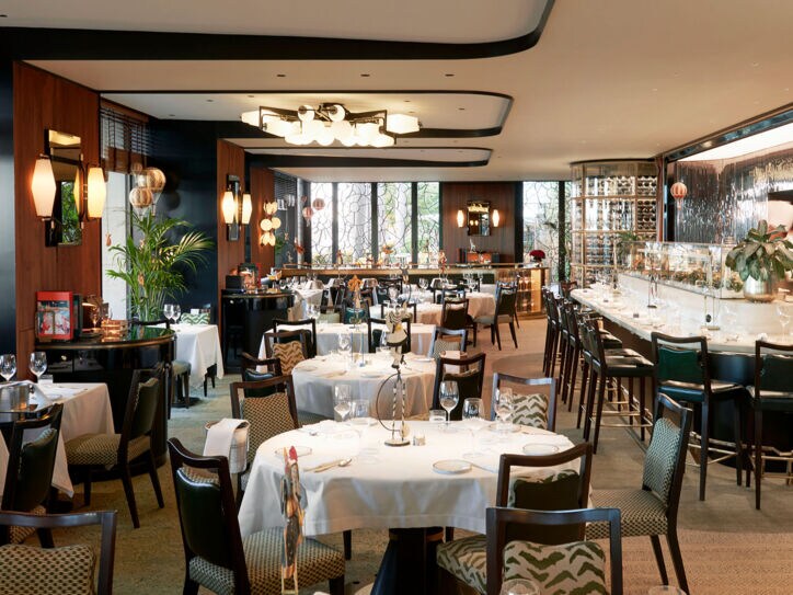 Edler Speisesaal mit eingedeckten Tischen und Barbereich in einem Luxusrestaurant.