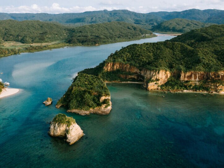 Luftaufnahme einer Inselgruppe mit bewaldeten Hügeln.