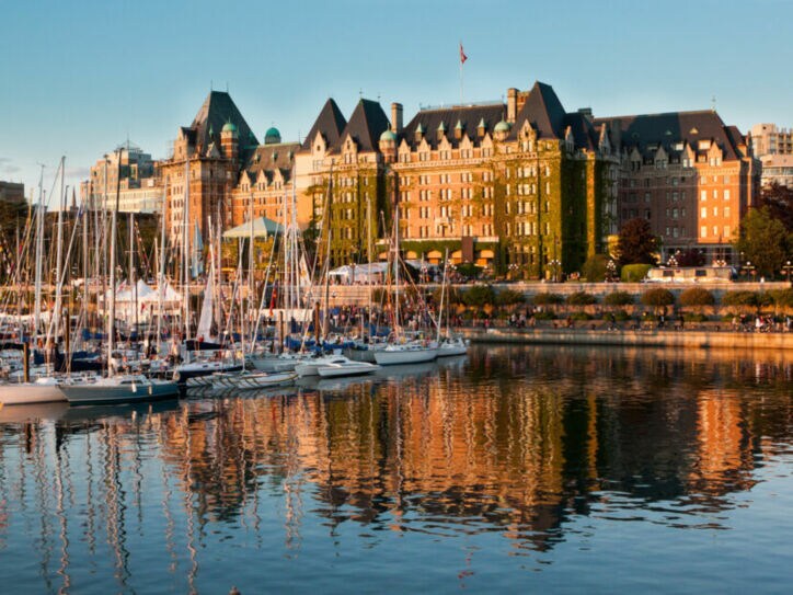 Boote vor dem historischen Fairmont Empress Hotel im Inner Harbour an einem klaren sonnigen Tag.