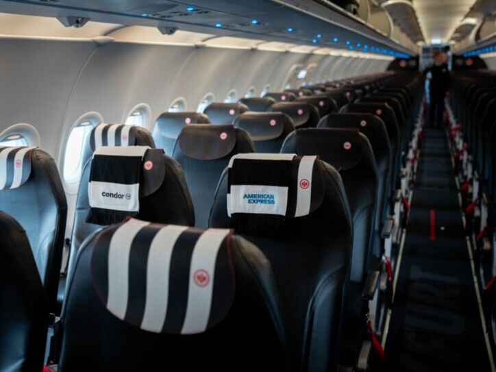 Sitzplätze eines Condor Business-Class-Fluges mit einem Fanschal der Eintracht Frankfurt über der Lehne.