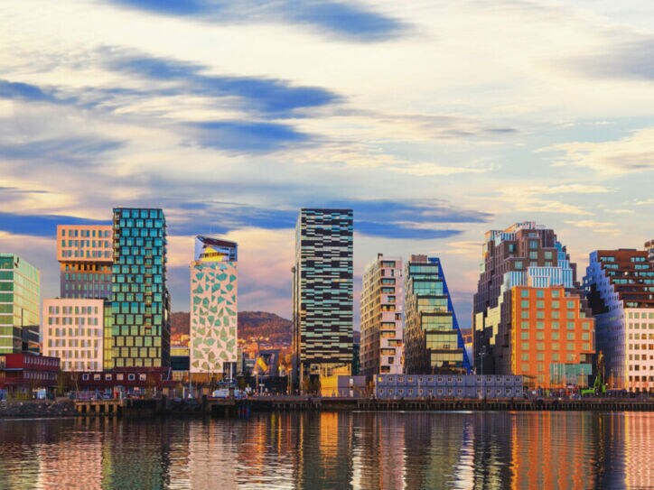 Eine Skyline mit verschieden Hochhäusern liegt direkt an einem Fluss.