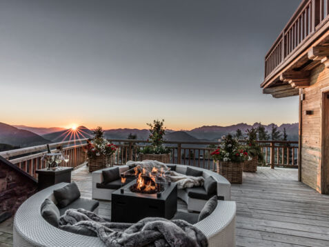 Eine Terrasse mit Feuerstelle und Blick über die Alpen