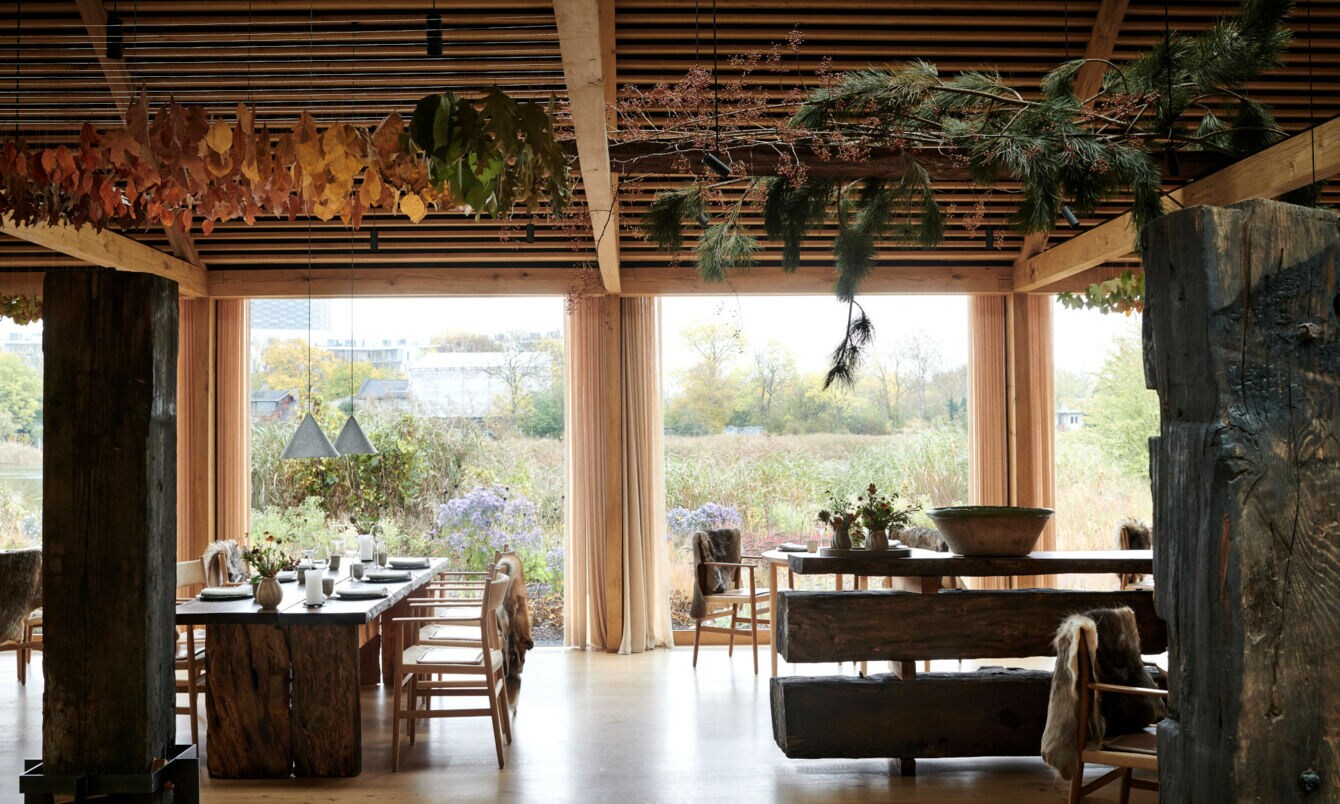 Innenraum eines Restaurants mit Blick nach draußen auf eine Wiese voller Wildblumen