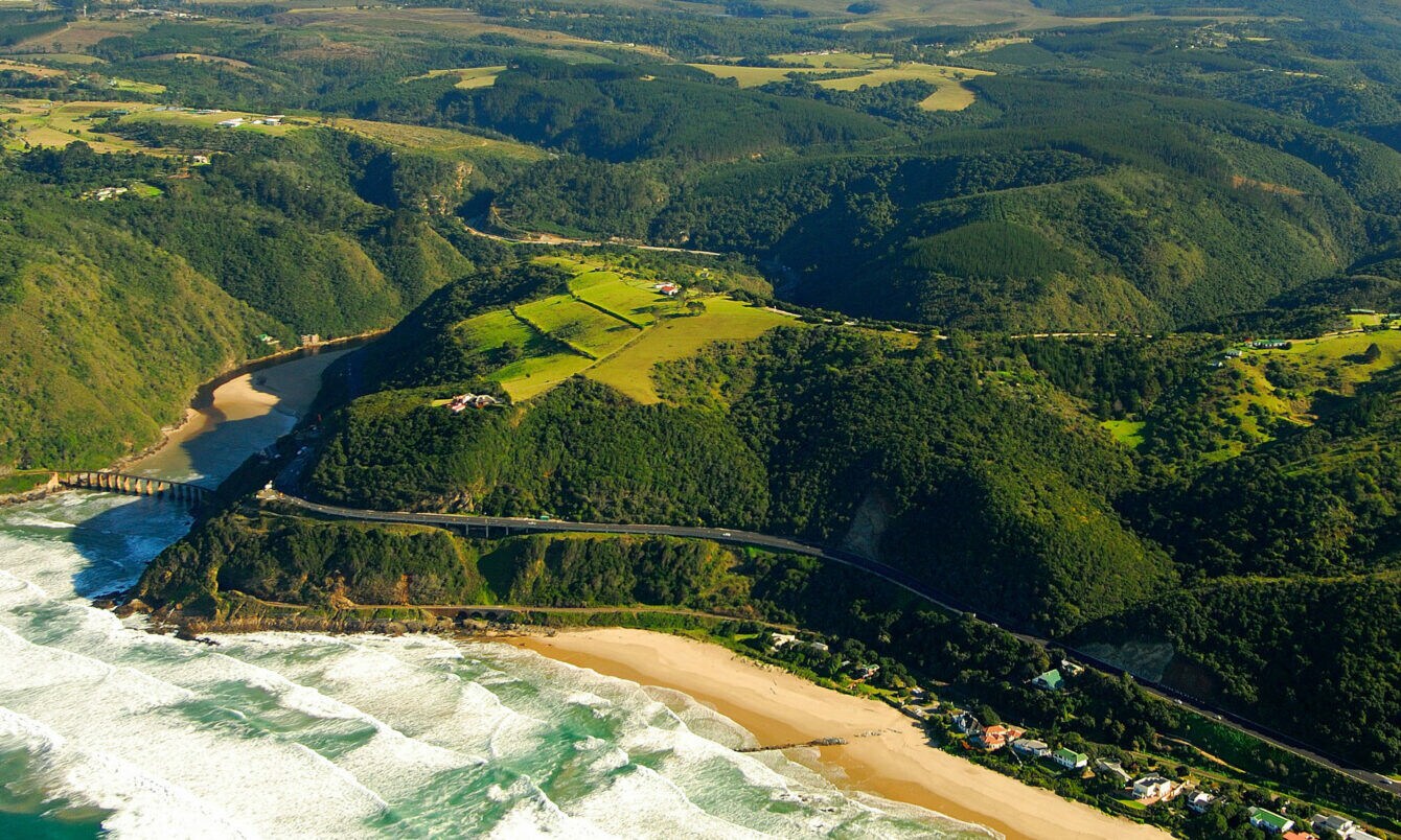 Luftaufnahme der Garden Route, die durch grüne Wälder entlang der Küste führt