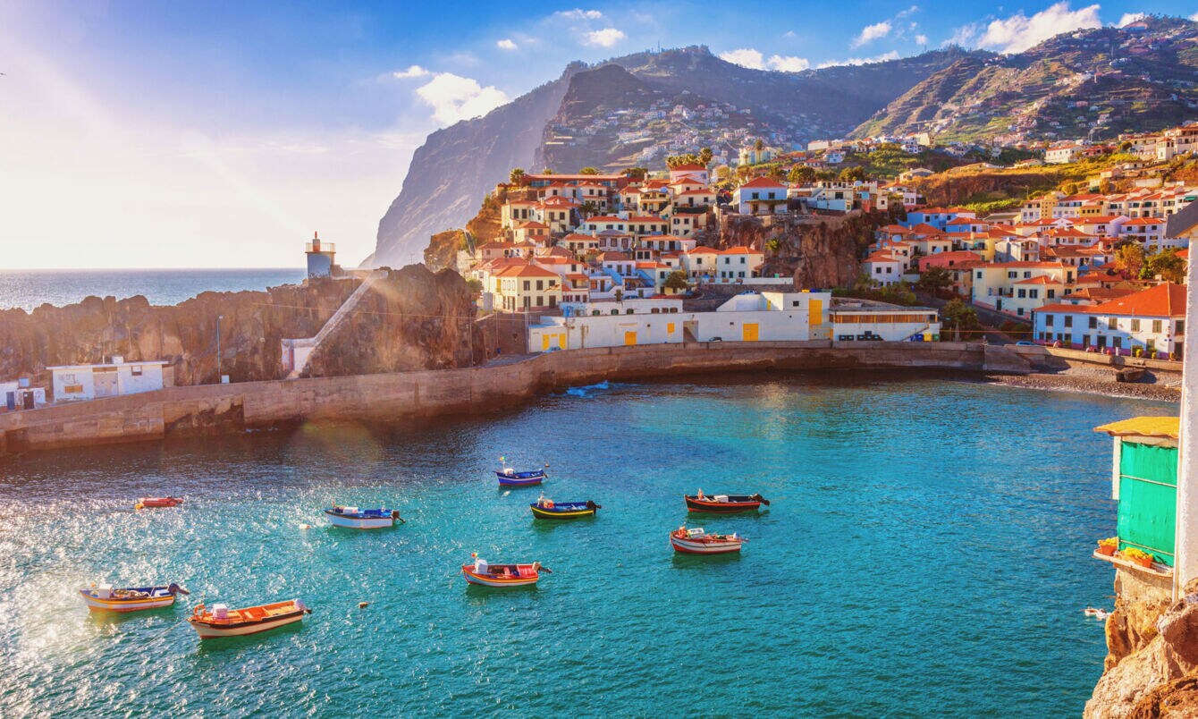 Panorama von Funchal auf Madeira mit Booten im Vordergrund und Bergen im Hintergrund.