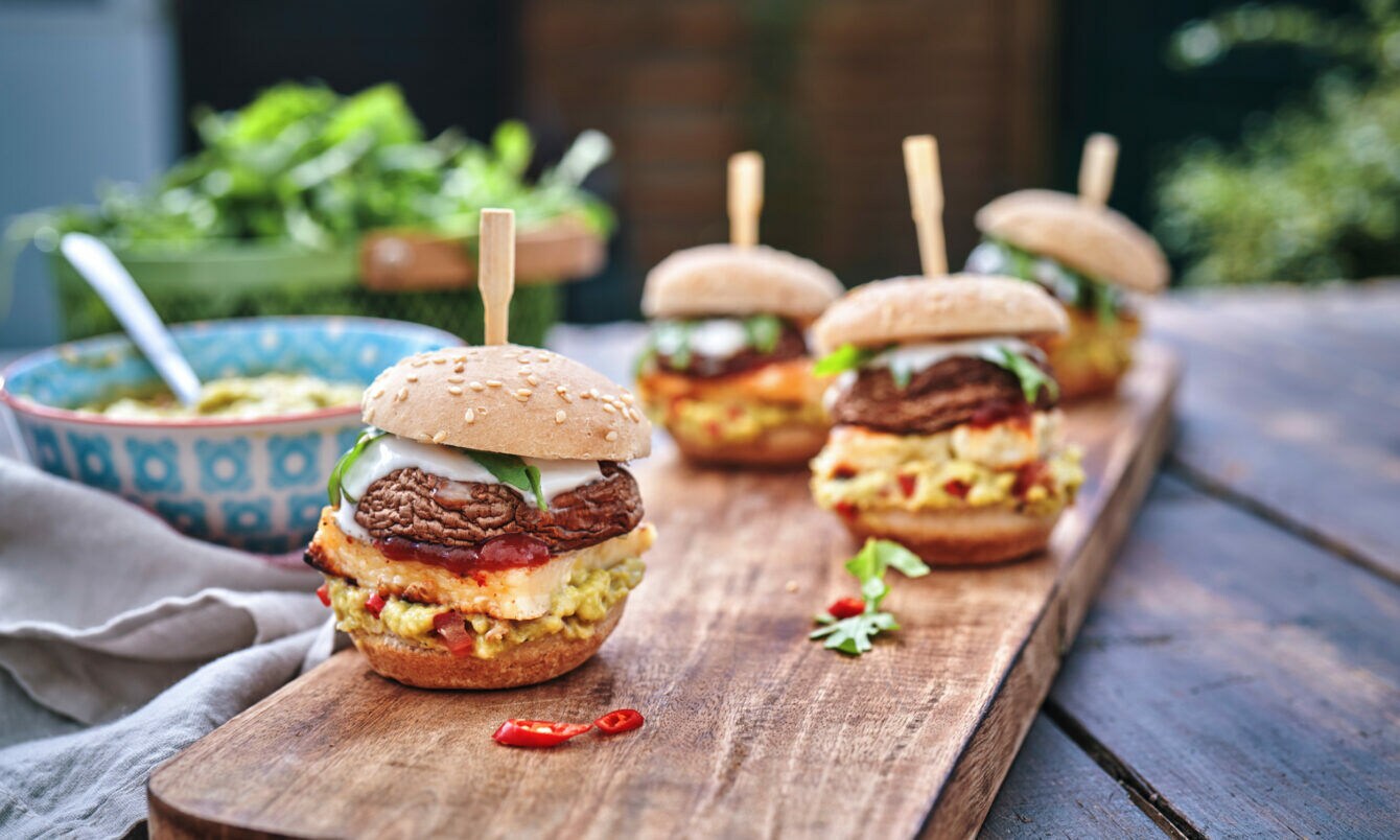 Kleine Burger mit Champignon-Pattys auf einem Brett.