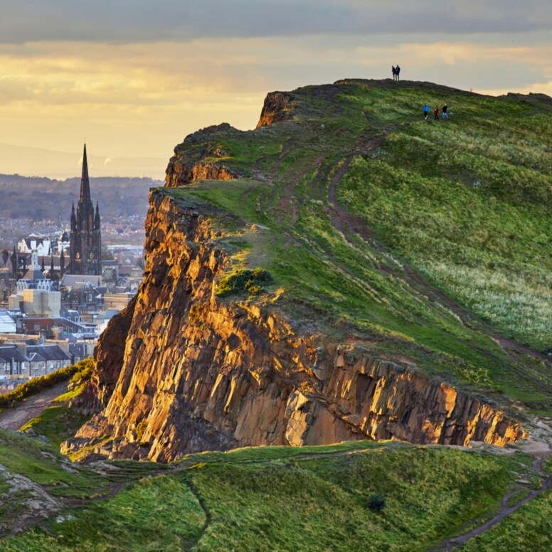 Blick auf schroffe Berglandschaft, dahinter eine Stadt