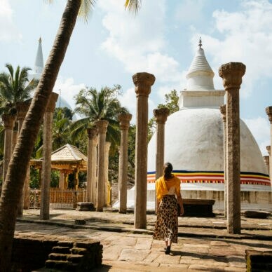 Rückansicht einer Frau in einer Tempelanlage in Sri Lanka.