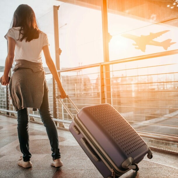 Frau zieht Koffer durch den Flughafen