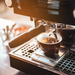 Espresso fließt aus einer Maschine in eine Tasse