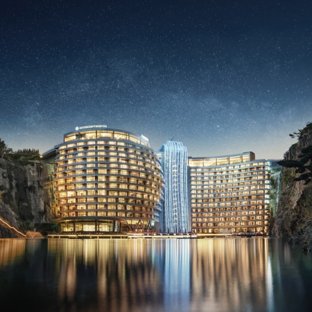 Blick auf das erleuchtete futuristische und zwischen steilen Felsen eines Steinbruchs gelegene InterContinental Shanghai Wonderland.