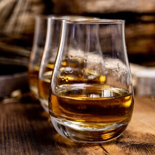 Eine Reihe von Whiskygläsern auf einem Holztisch