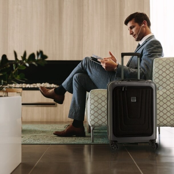 Ein Mann in einem Sessel, neben ihm steht ein Koffer