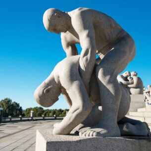 Eine steinerne Skulptur, bei der ein Mann einen zusammengesunkenen Mann hält