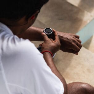 Ein Mann in Sportkleidung mit Armbanduhr mit Digitalanzeige am Handgelenk
