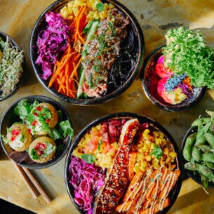 Verschiedene Speisen in leuchtenden Farben, die in Schalen auf einem Tisch angerichtet sind