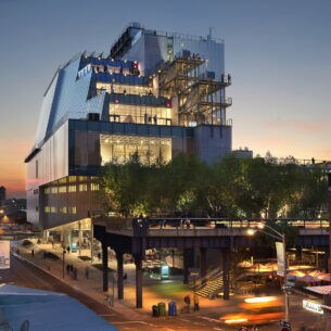 Beleuchteter, moderner Gebäudekomplex des Whitney Museum of Art mit Besuchern auf unterschiedlichen Terrassen in der Abenddämmerung