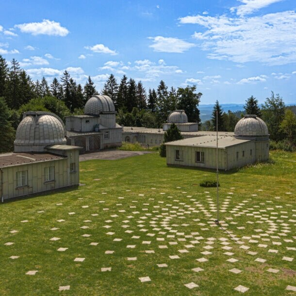 Gelände der Sternwarte Sonneberg, auf dem sich mehrere Gebäude mit Kuppeln befinden, daneben eine Installation mit Markierungssteinen, die sich kreisförmig am Boden um eine Stange anordnen
