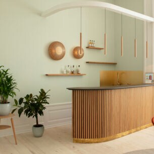 Ein Küchentresen aus Holz und runden Holzlampen an der Wand.