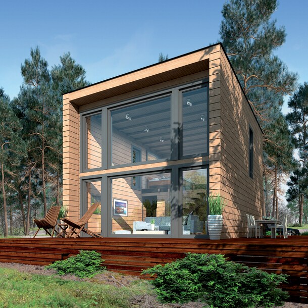 Ein modernes Blockhaus mit bodentiefer Glasfront und Terrasse im Wald