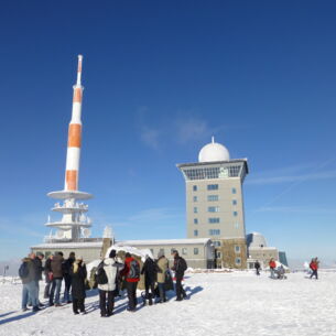 Eine Gruppe Touristen auf dem Gipfel des Brocken im Winter.