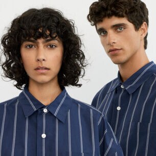 Close-up einer jungen Frau und eines jungen Mannes in einem blauen Unisex-Hemd mit weißen Streifen