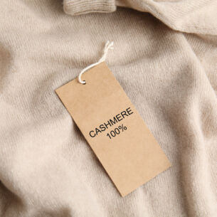 Ein Kaschmir-Pullover mit Etikett, auf dem „Cashmere 100 %” steht.