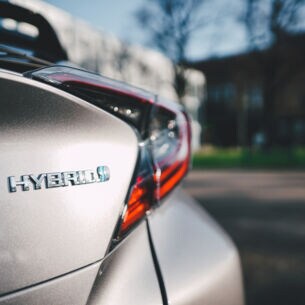 Hybrid-Logo an einem silbernen Auto