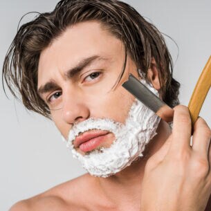 Ein Mann rasiert sich mit Rasiermesser