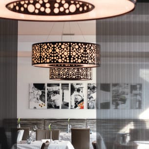 Restaurant mit gedeckten Tischen und Schwarz-Weiß-Bildern an der Wand