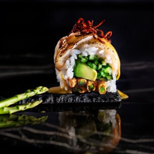 Kunstvoll angerichtetes Sushi mit grünem Spargel als Deko