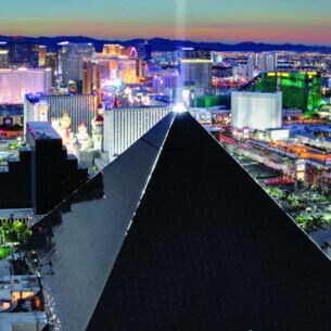 Luftaufnahme von Las Vegas bei Nacht mit einem schwarzen, pyramidenförmigen Gebäude