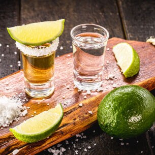 Zwei Gläser Tequila mit Limetten und Salz